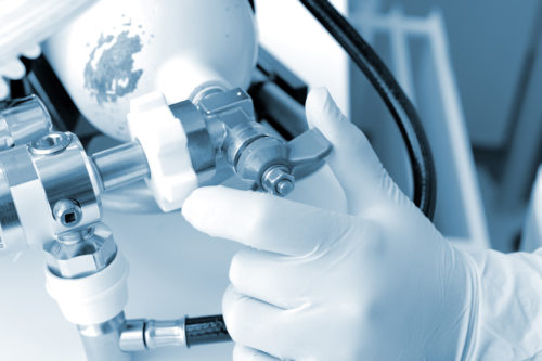 Hand on the oxygen cylinder valve in monochrome. Hand on the oxygen cylinder valve in monochrome.